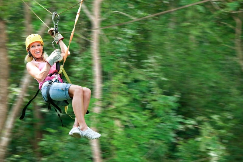 woman ziplining through the trees on Roatan island