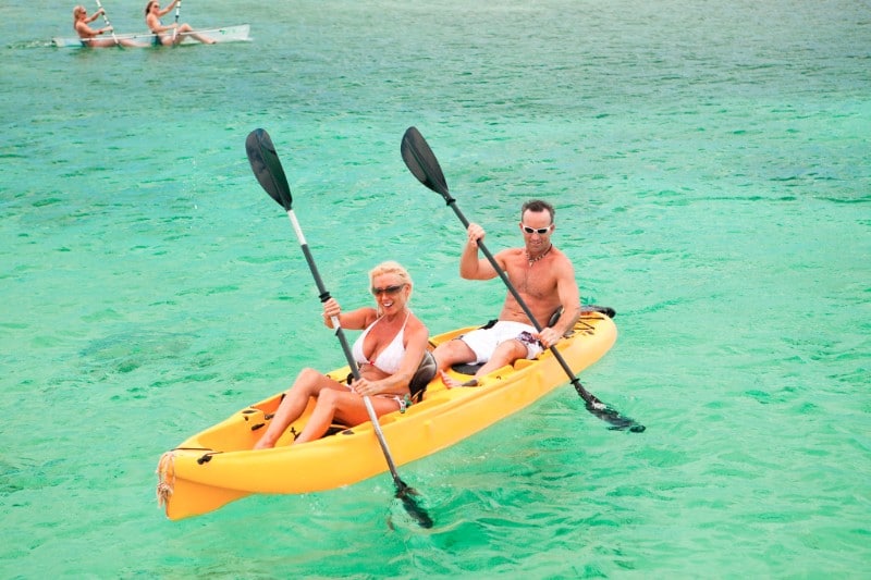 couple in a double kayak in turquoise water - things to do in Roatan Honduras