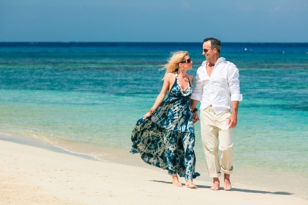 couple strolling a white sand beach in Roatan Honduras