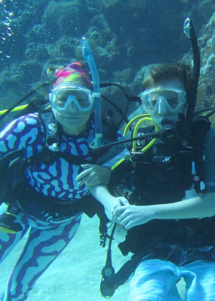 multi-generational vacation - Ann Addison scuba diving with her grandson in Roatan