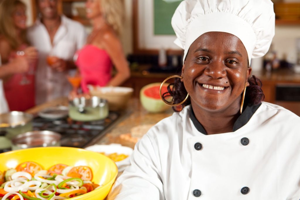smiling chef with diners in the background - Roatan things to do